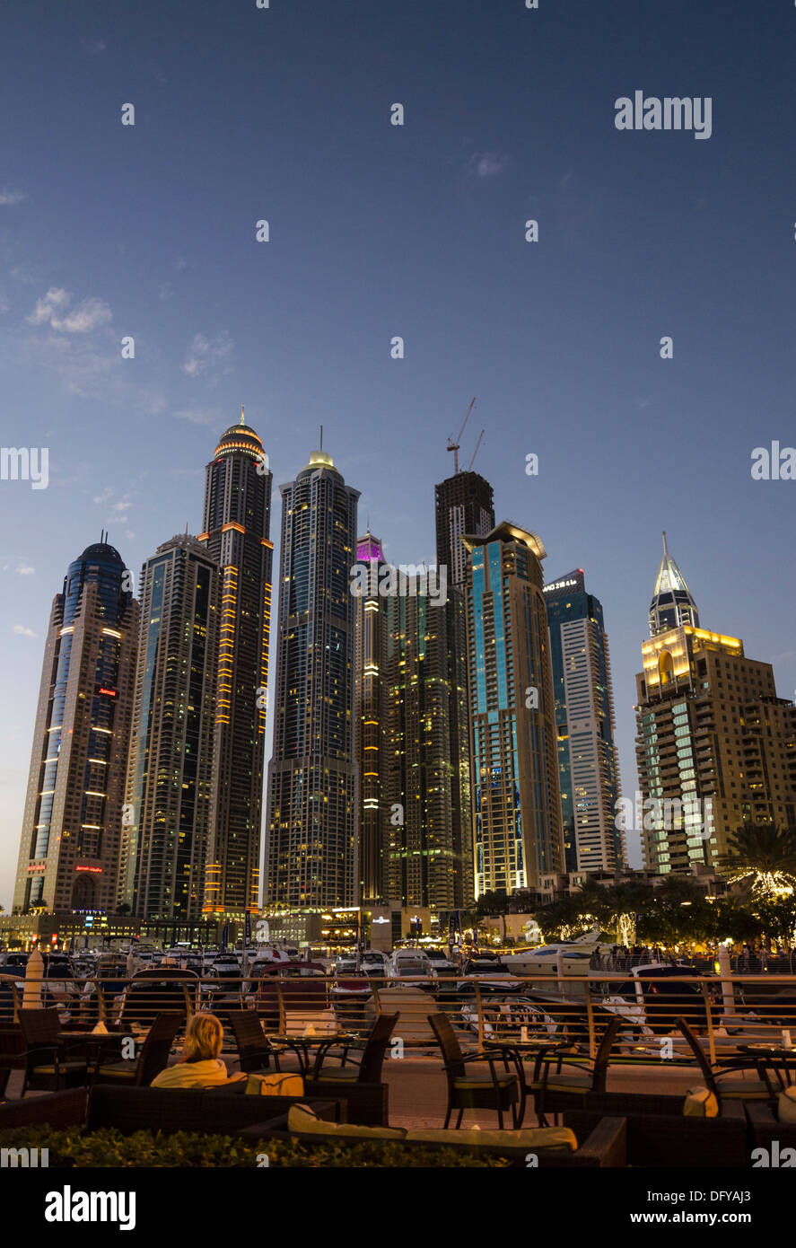 Night cityscape and outdoor restaurant on the promenade that meanders around Dubai Marina, Dubai, UAE Stock Photo