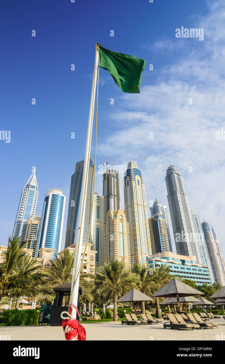 Skyscrapers of Dubai Marina tower above a Green Flag over the beach of The Westin Dubai Mina