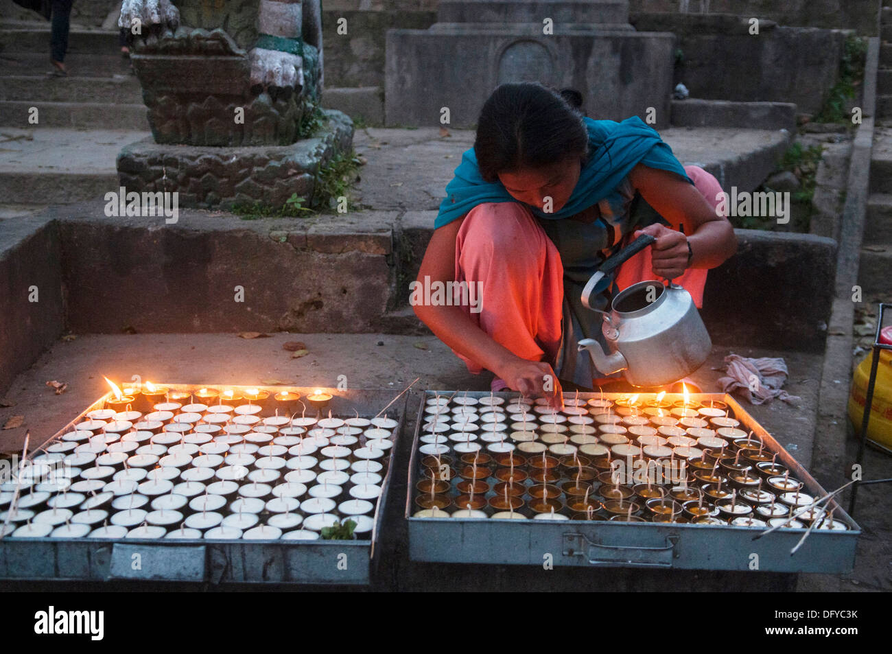 woman lighting butter candles at the Swayambunath Tibetan Buddhist