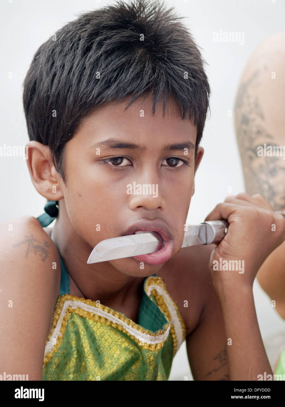 Knife in boy´s mouth at the bizarre Vegetarian Festival, Phuket, Thailand Stock Photo Alamy