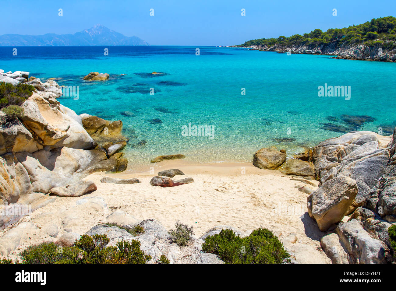 Rocky cliff above the beautiful clear water of the Aegean sea Stock Photo