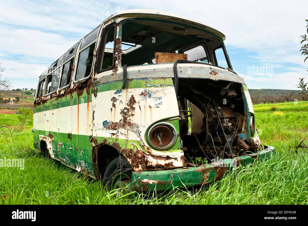 Abandoned old bus in a green field Stock Photo