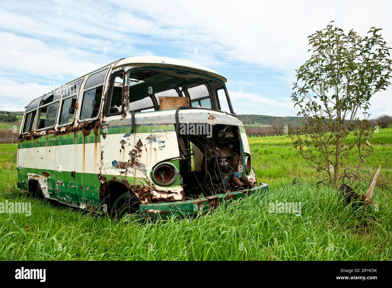 Abandoned old bus in a green field Stock Photo