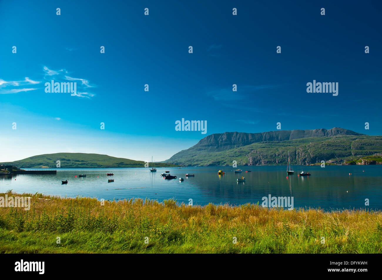 Fishing boats on calm water with mountain reflection Stock Photo - Alamy