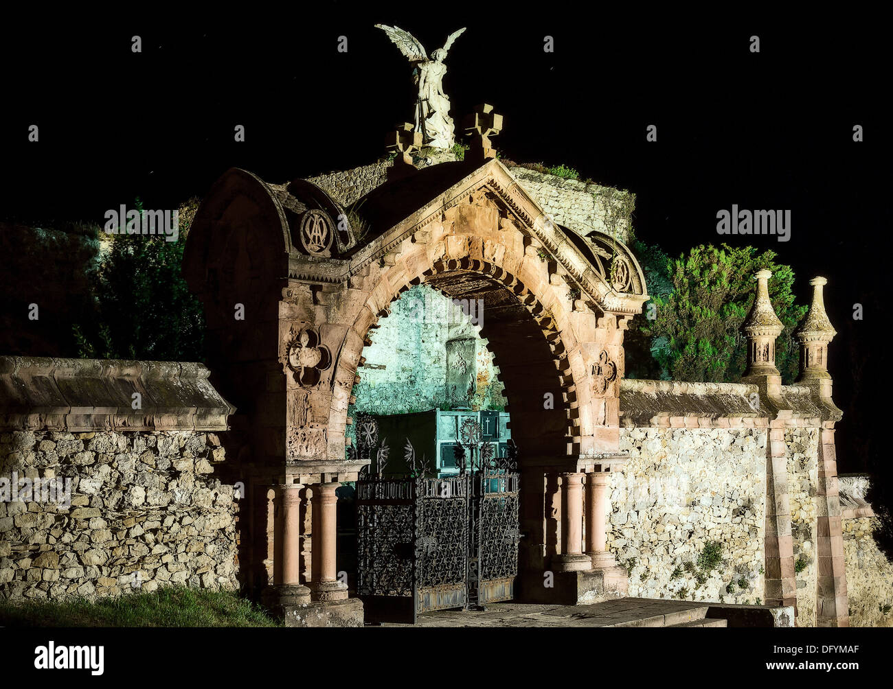 entrance to a gothic cemetery by night with an angel statue Stock Photo