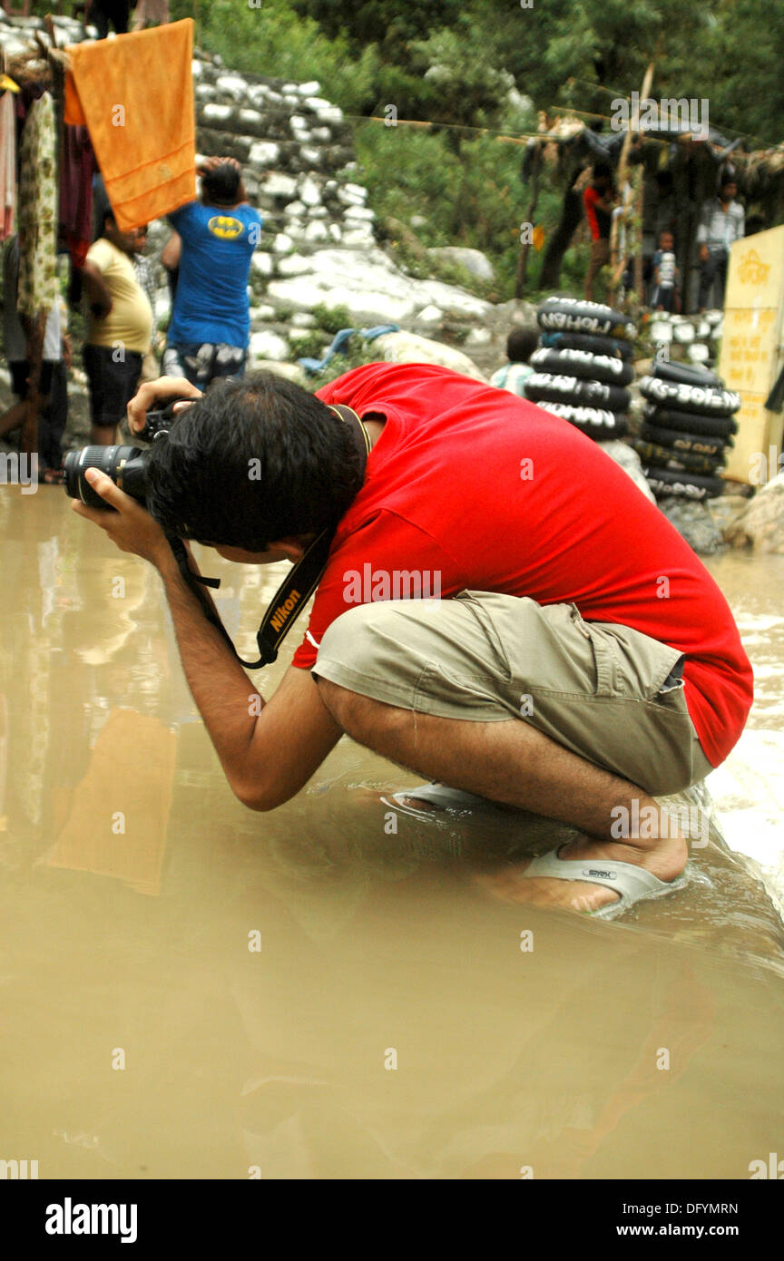 A photographer taking picture in difficult situations. Stock Photo