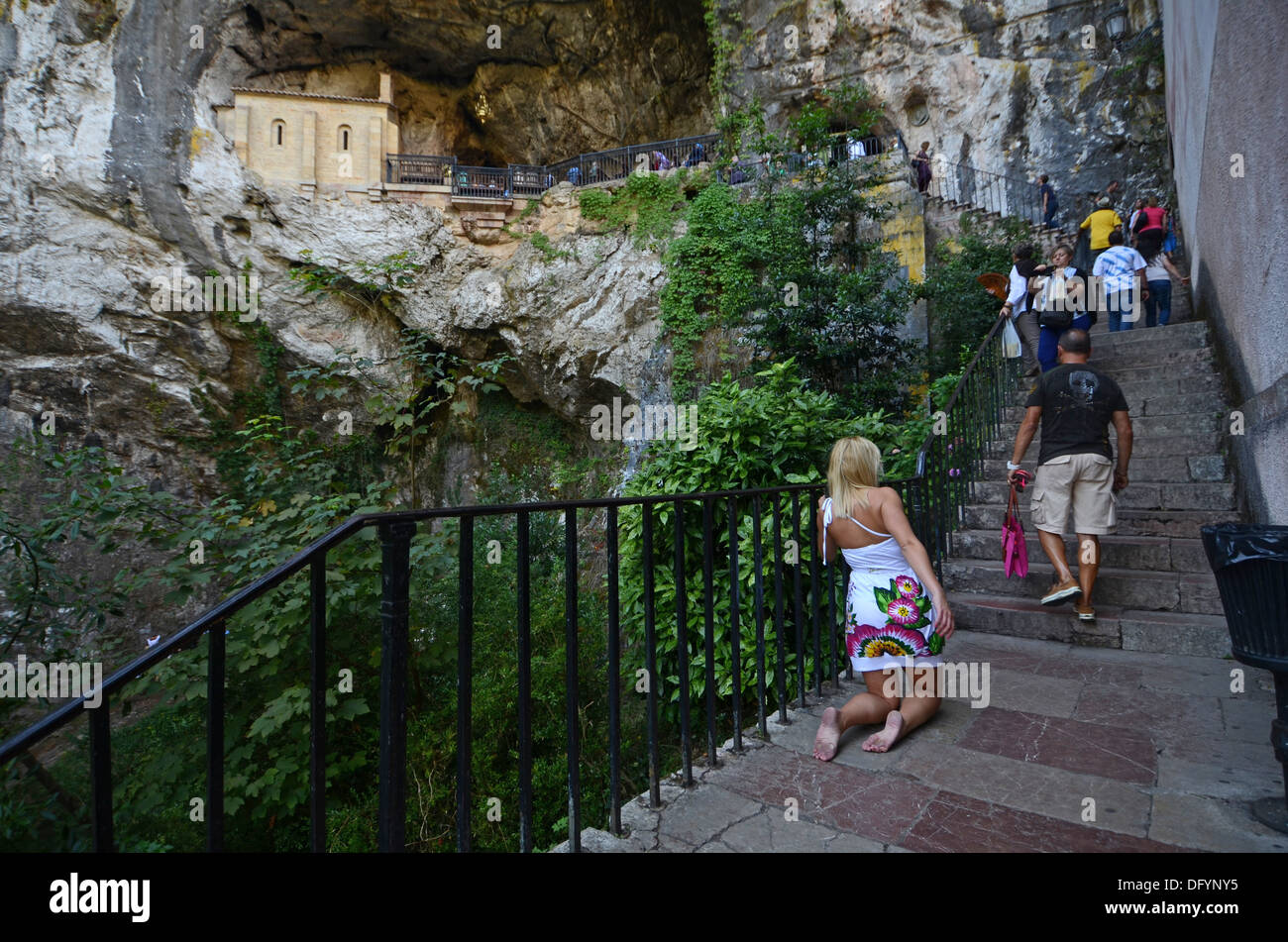Young woman climbs stairs on her knees in shrine of Our Lady of Covadonga Stock Photo
