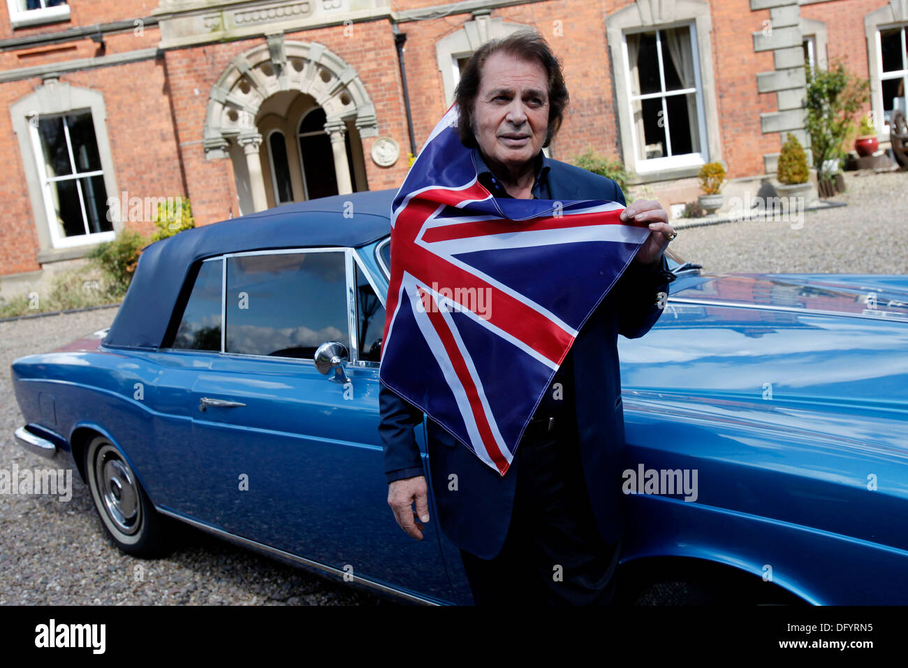 British pop singer Engelbert Humperdinck poses for a photograph next to his car and a Union Jack flag during a photocall at his Stock Photo