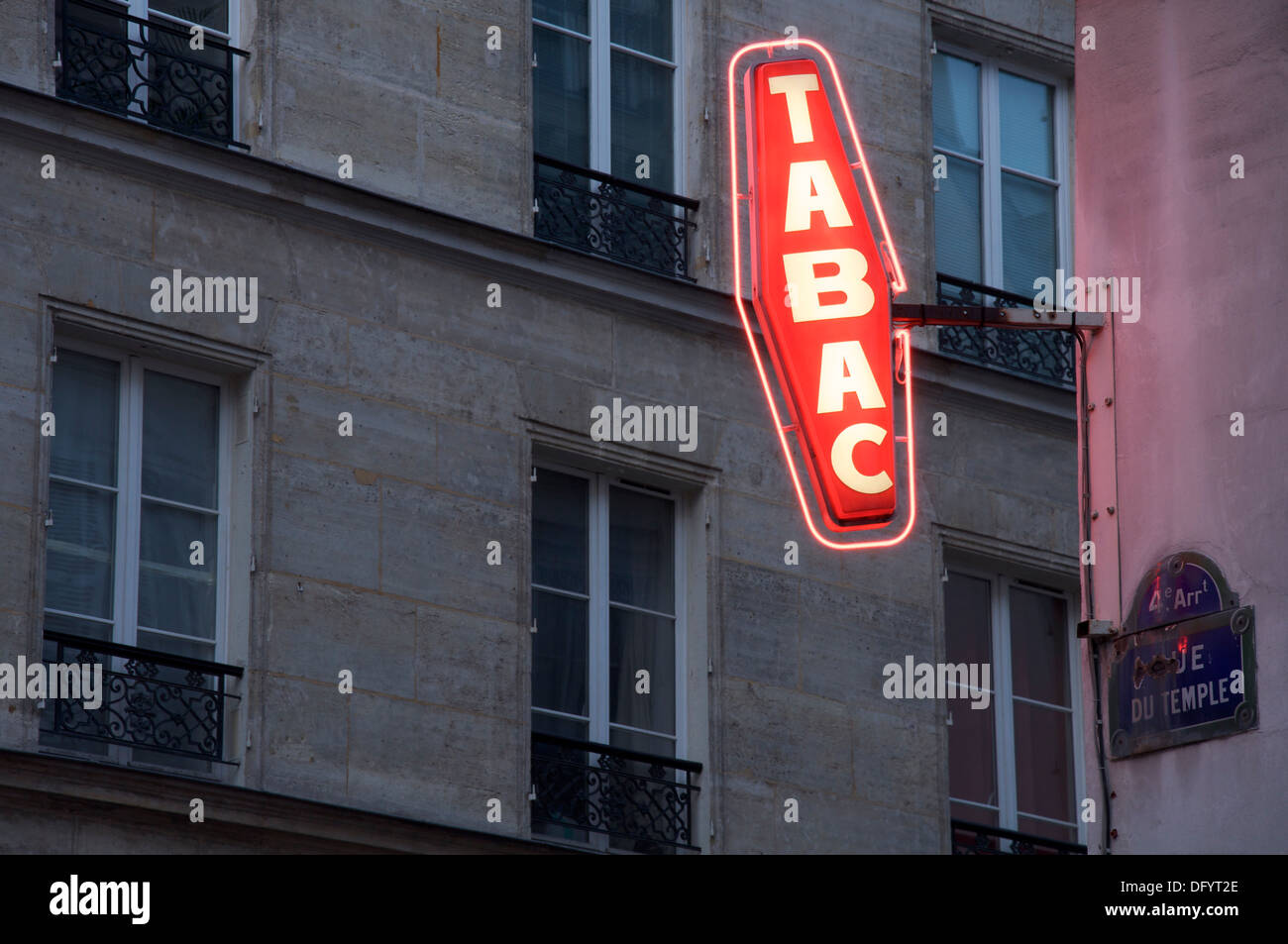 Signs. The red neon illuminated diamond symbol of a traditional French Tabac sign. Indicates a café or bar licensed to sell tobacco. Paris, France. Stock Photo