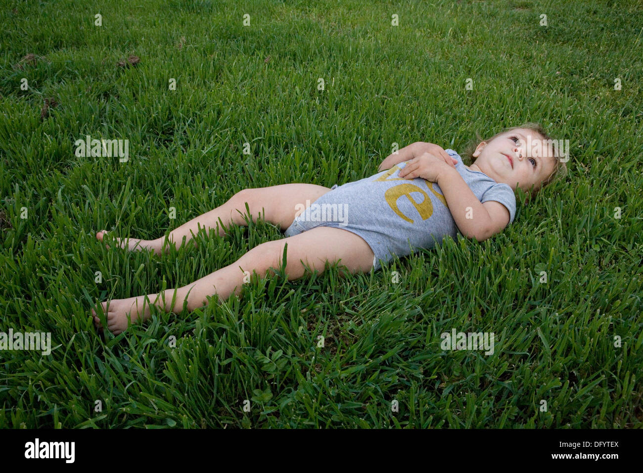 Cute Toddler Girl Playing in grass Stock Photo - Alamy