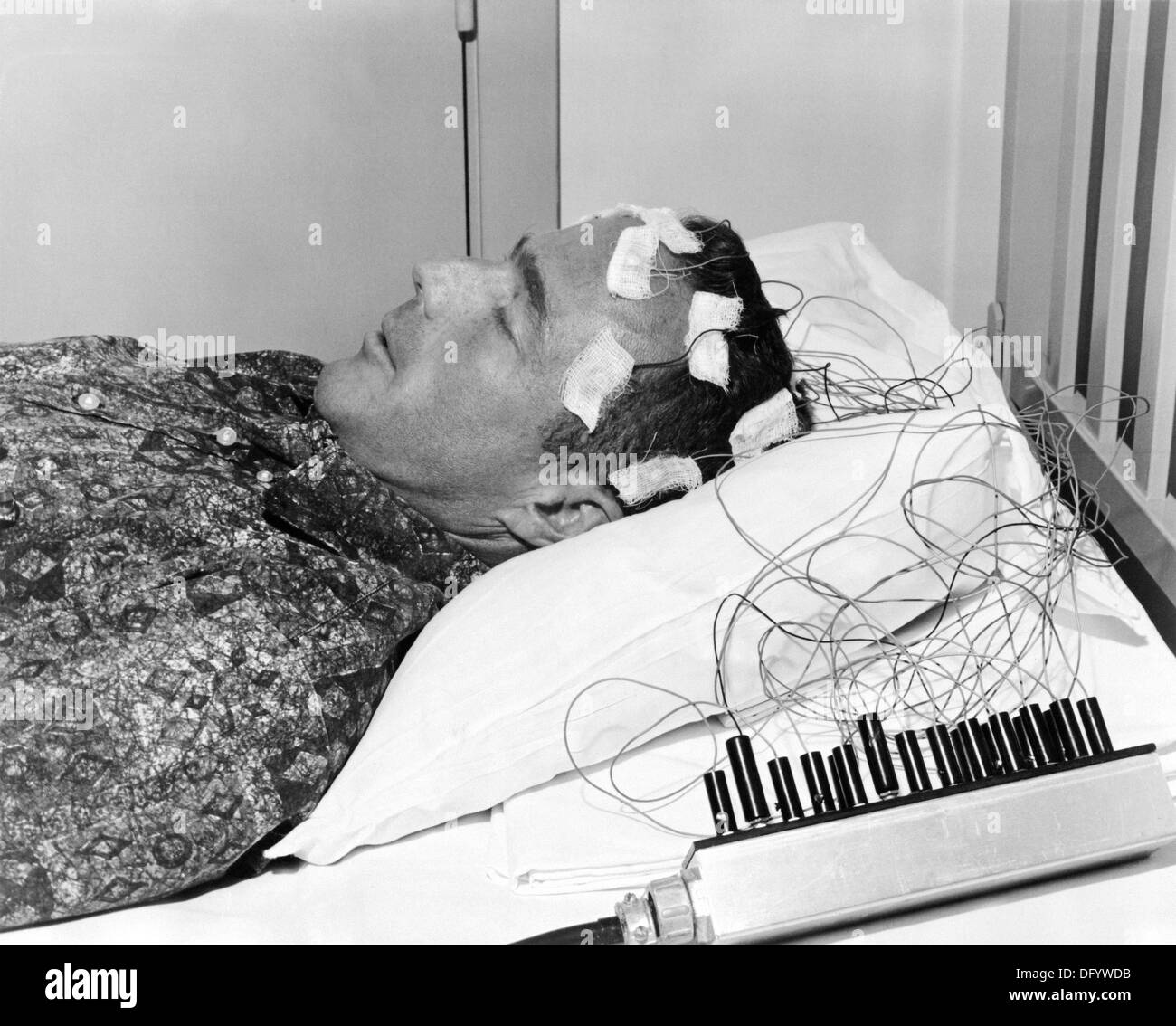 NASA Astronaut Scott Carpenter lies on a bed with biosensors attached to his head during astronaut training activities April 9, 1962 in Cape Canaveral, FL. Carpenter one of the original Mercury Seven astronauts and the second American to orbit the Earth died October 10, 2013 at age 88. Stock Photo