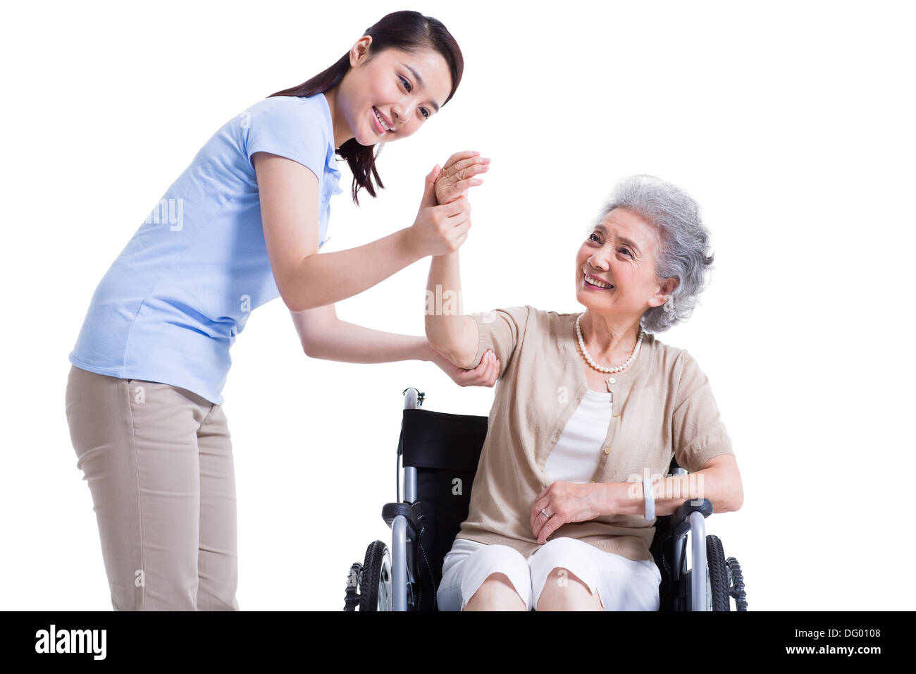 Female nursing worker helping senior man doing exercise Stock Photo