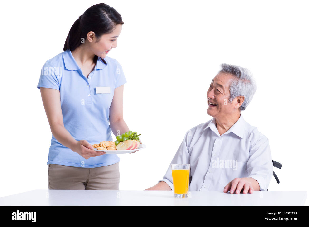Nursing assistant serving food for disabled senior man Stock Photo Alamy