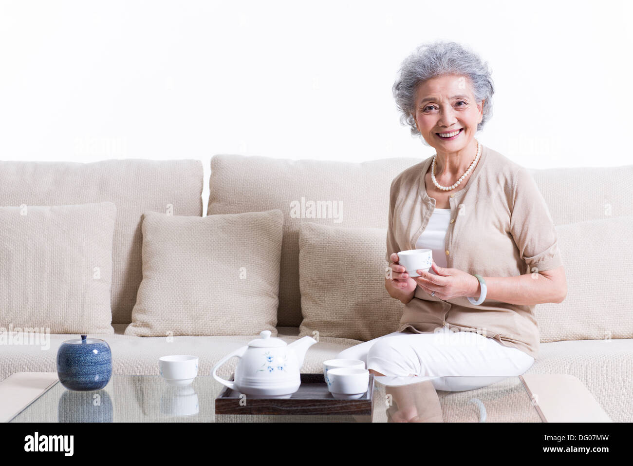 Cheerful senior woman having tea Stock Photo