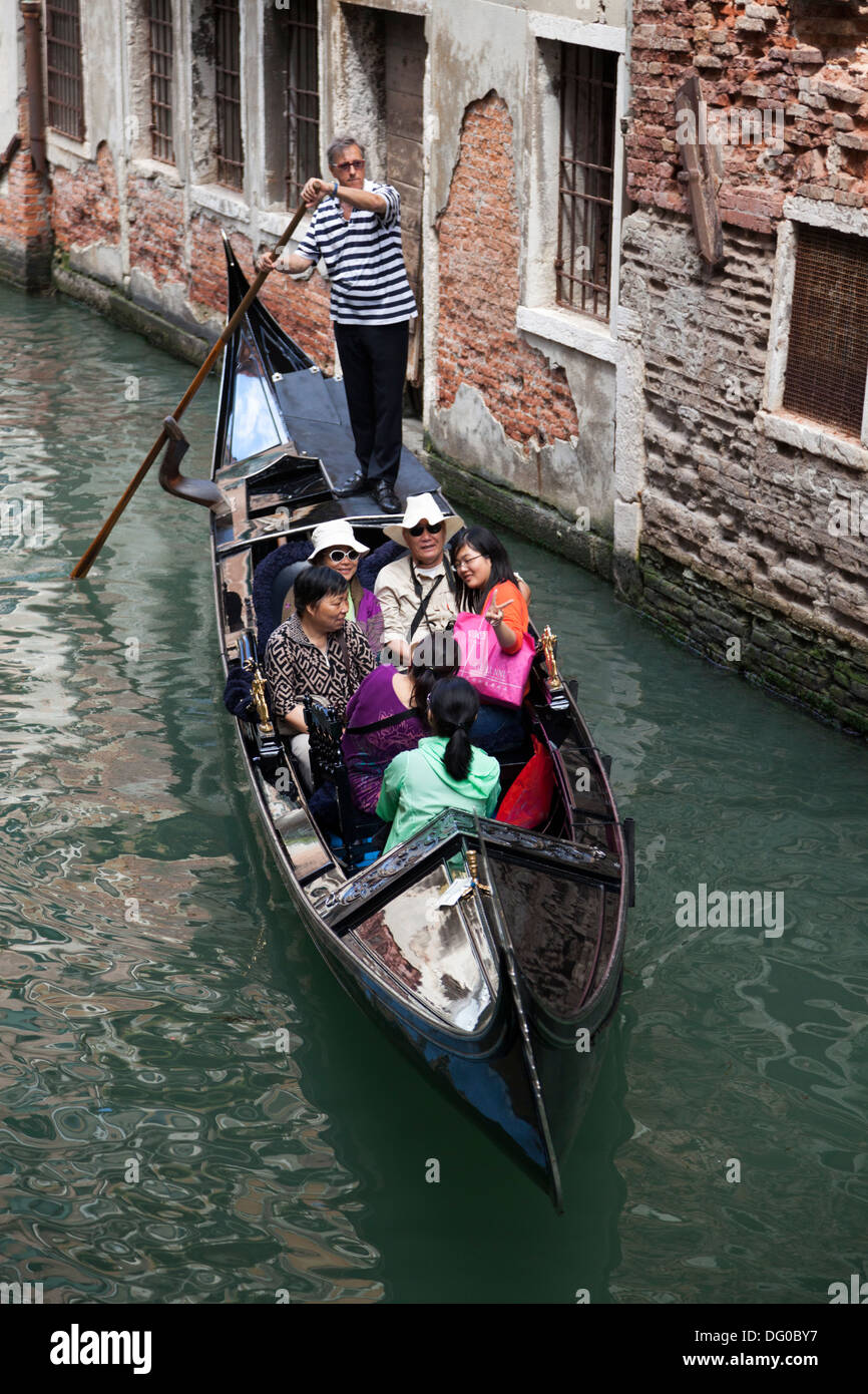 High-angle shot on a gondola from the vantage point of a Venetian bridge (Venice - Italy). Vue sur une gondole depuis un pont. Stock Photo