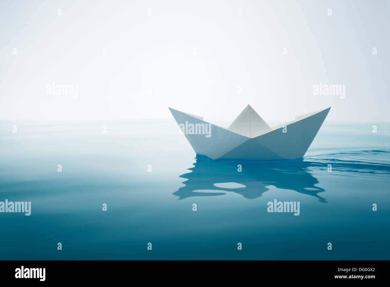 paper boat sailing on water with waves and ripples Stock Photo