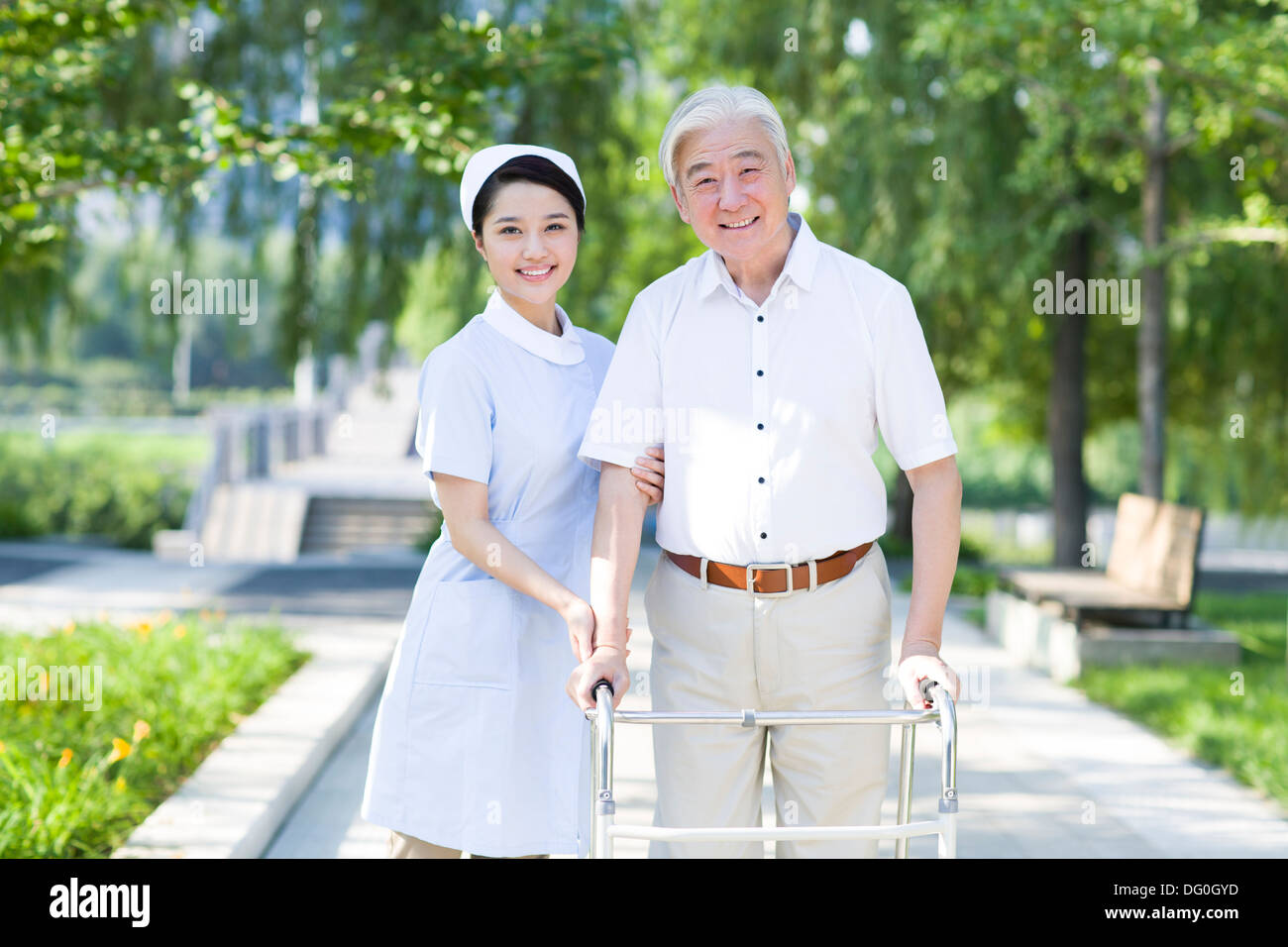 Senior man walking with walking frame under nurse's assistance Stock Photo