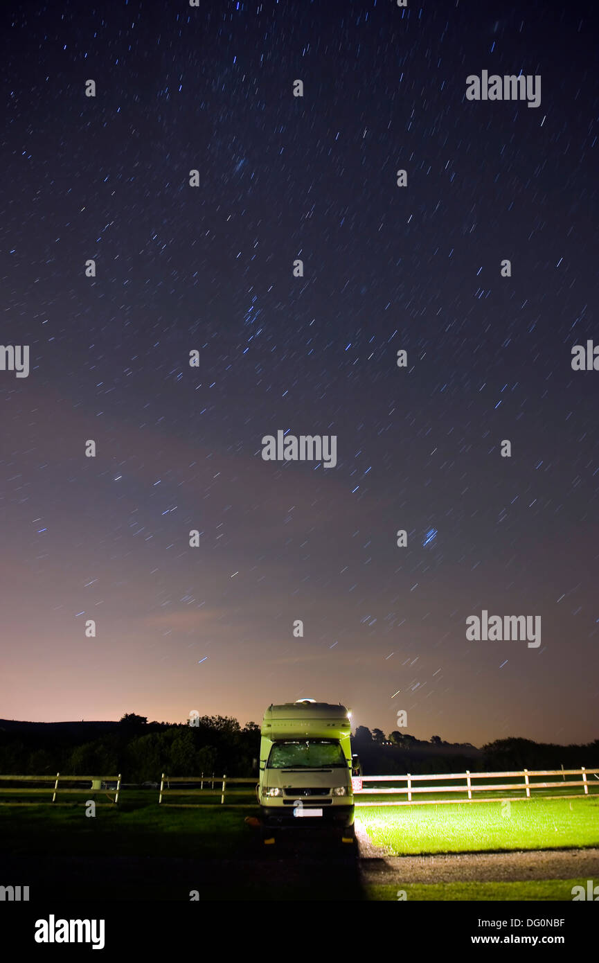Moving stars in the night sky above a camper van in Dorset, UK Stock Photo