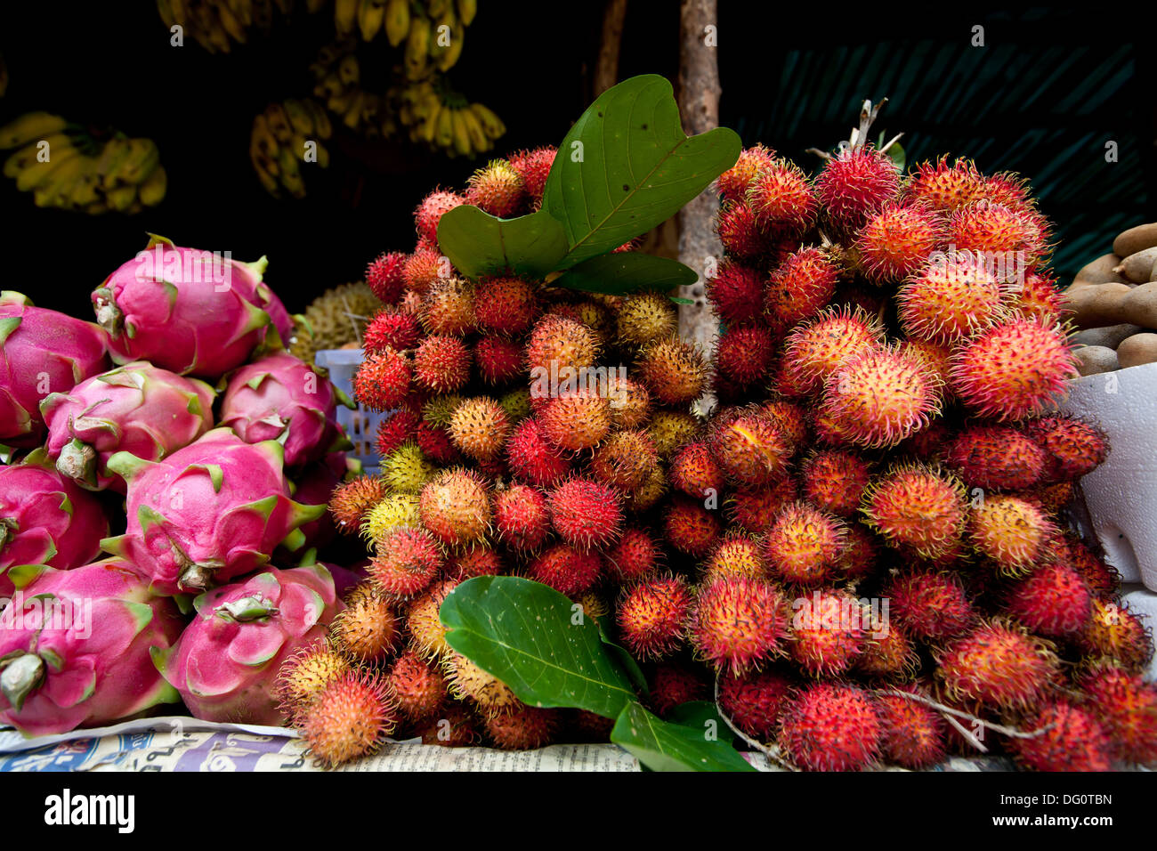 Closeup of a  bundle of rambutan and dragon fruit is displayed on a fruit stand in Cambodia. Stock Photo