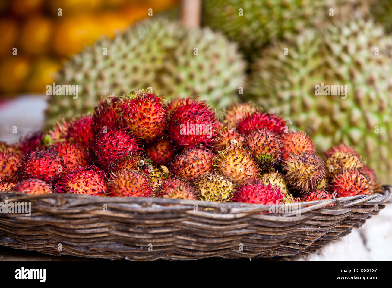 Closeup of a  pile of raw rambutan fruit is displayed on a fruit stand in a local market Stock Photo