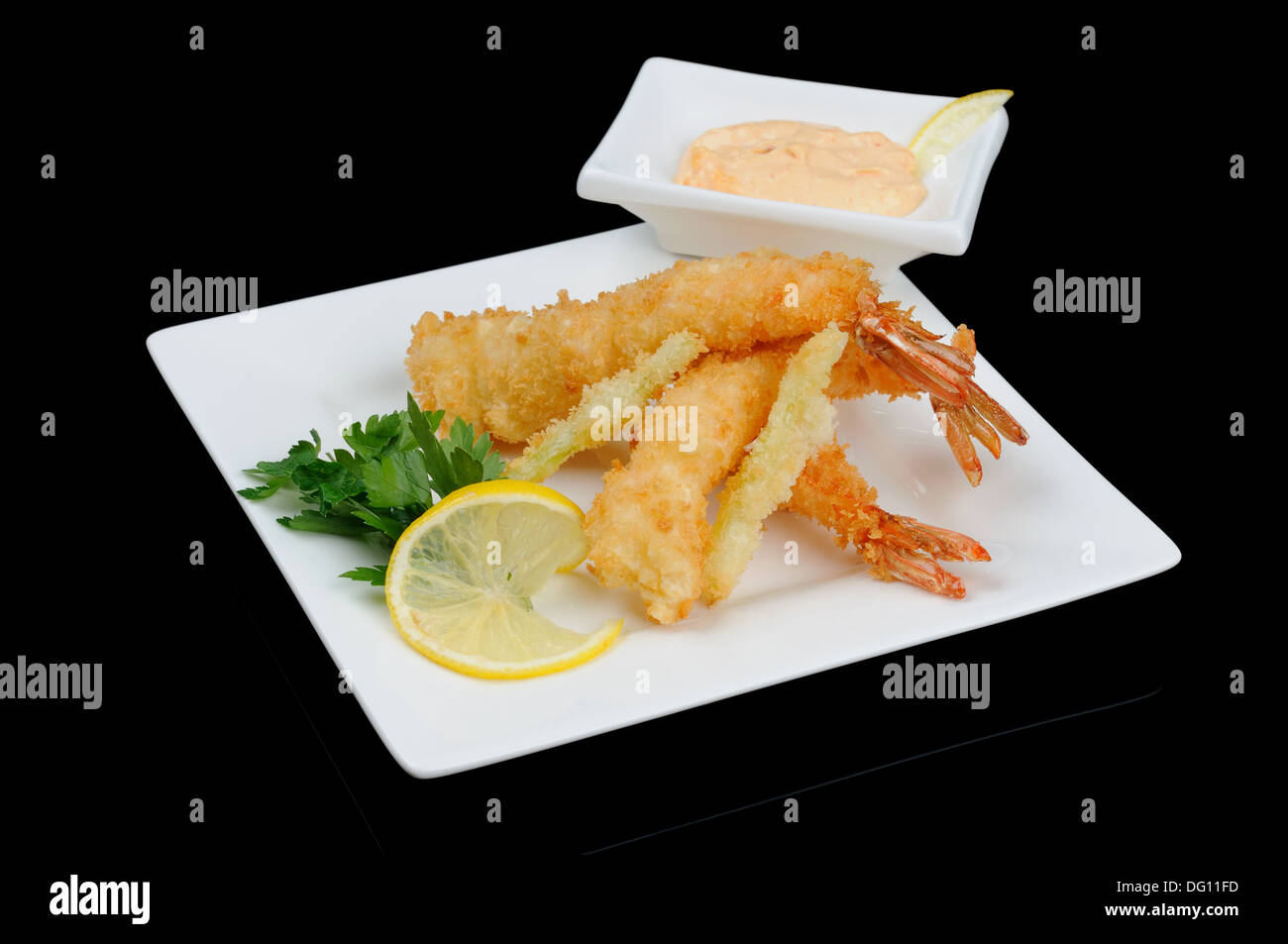 Three battered shrimps with sauce on white plate Stock Photo