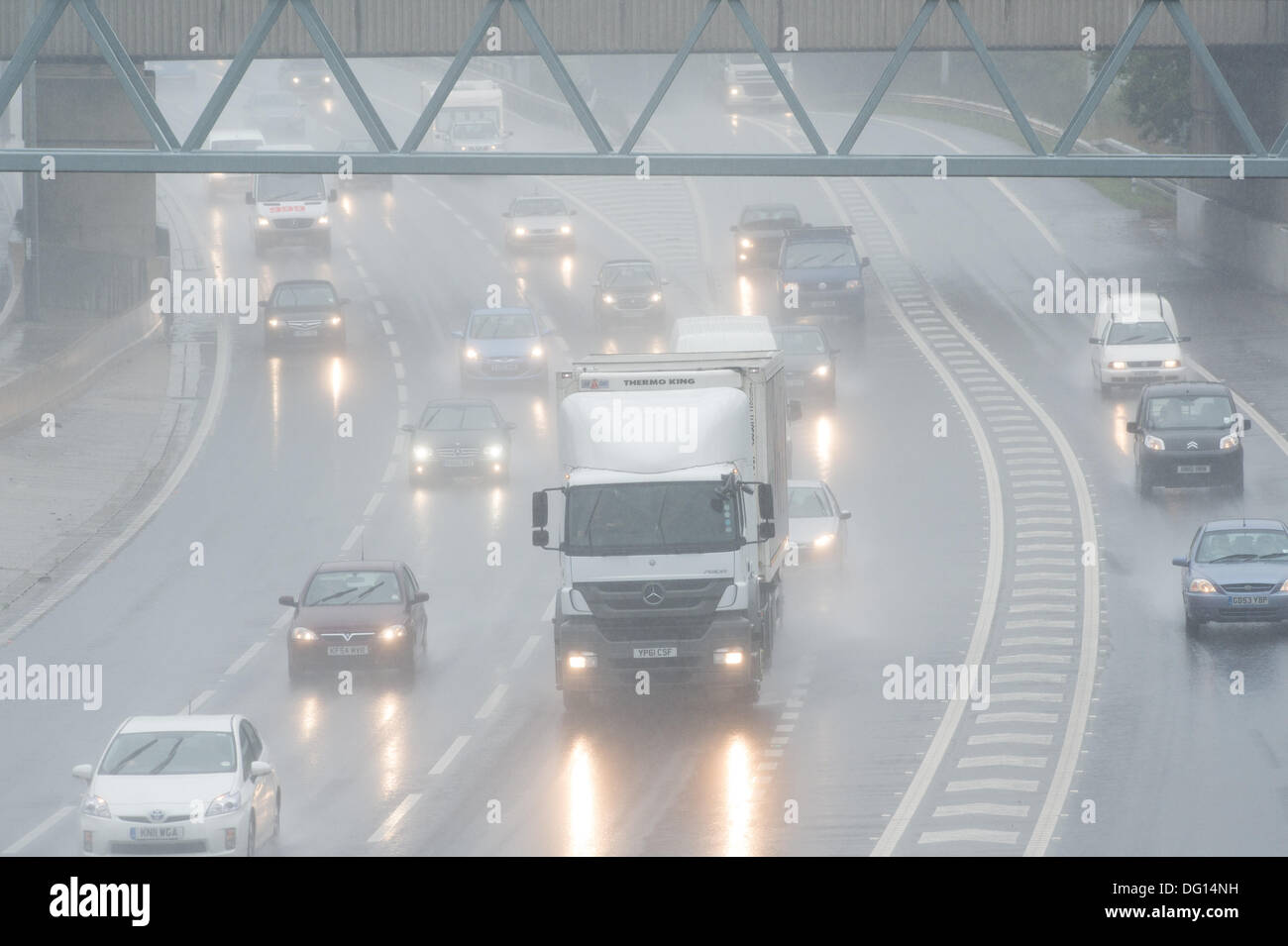 M25 at Brentwood, Essex. 11th October 2013. Weather warnings have been issued for strong winds and heavy rain for parts of the UK. Vehicles passing through the Essex section of the M25 negotiate heavy rain wind and spray making their journey hazardous. Credit:  Allsorts Stock Photo/Alamy Live News Stock Photo
