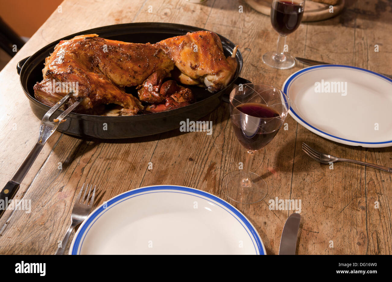 baked rabbit, served on an old table with wine Stock Photo