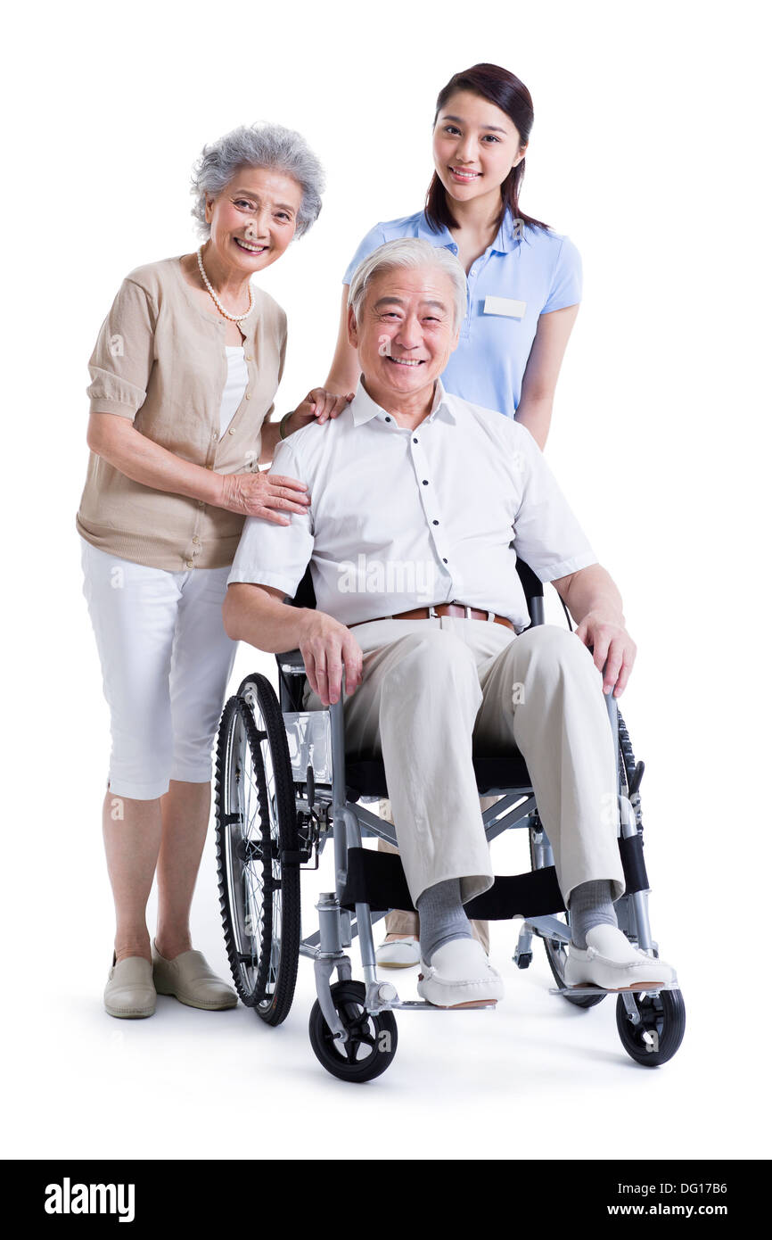 Wheelchair bound man with his wife and nursing assistant Stock Photo