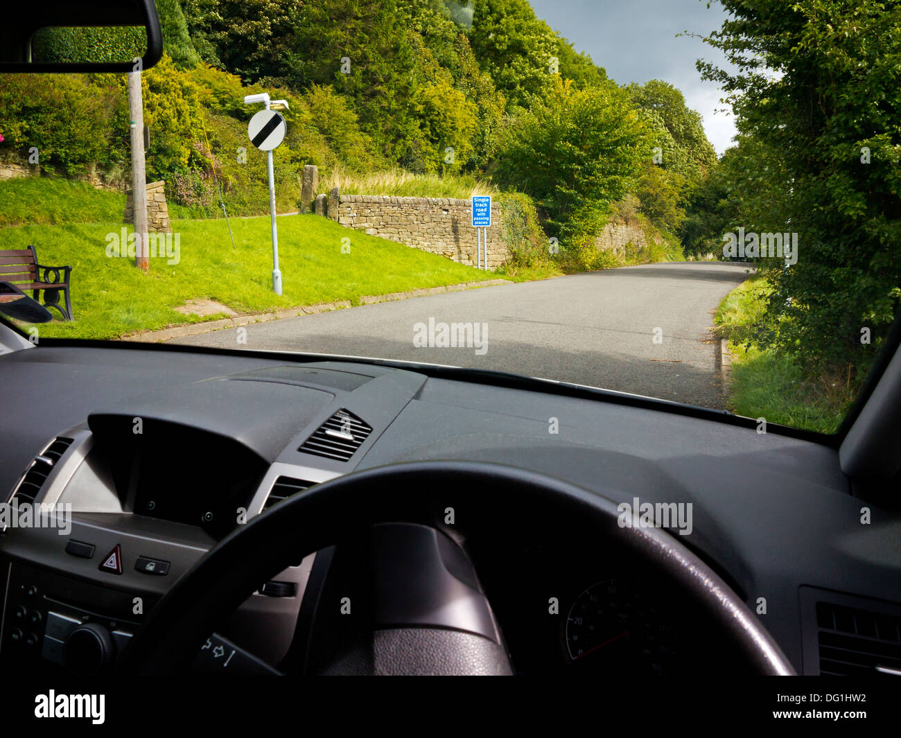 View from drivers seat of car down a quiet country lane with no traffic in Derbyshire England UK with national speed limit sign Stock Photo