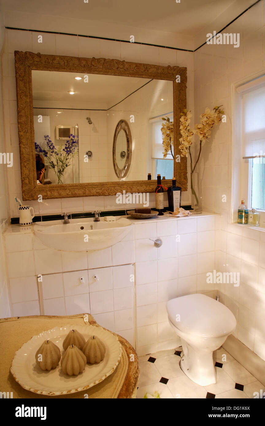 Large rectangular mirror above toilet and vanity unit with basin in ...