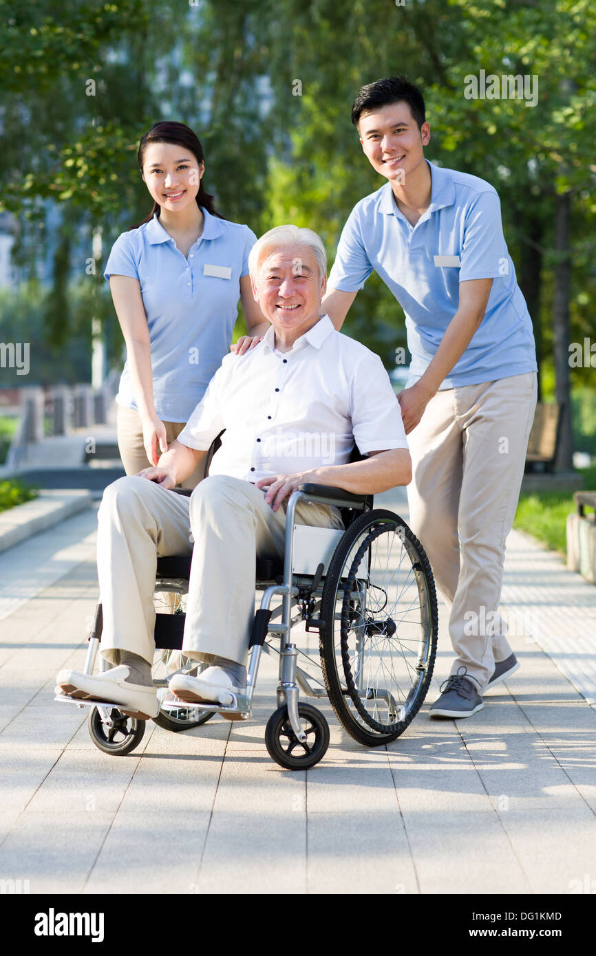 Wheelchair bound man with nursing assistants Stock Photo Alamy
