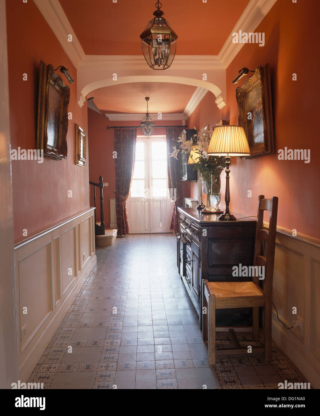 White panelled wainscot and tiled floor in red French country hall with