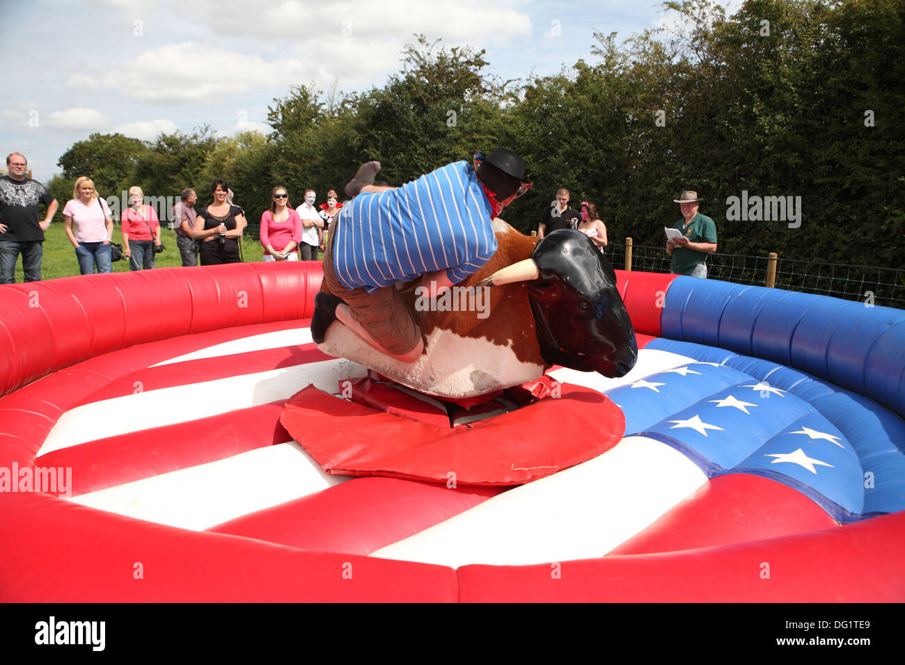 Riding a bucking bronco in fancy dress Stock Photo