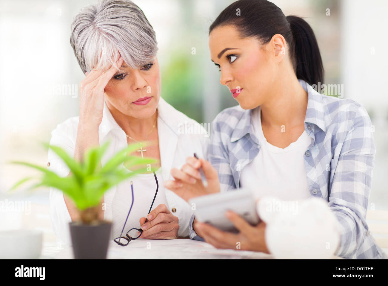 young woman helping senior mother sorting out her finances at home Stock Photo