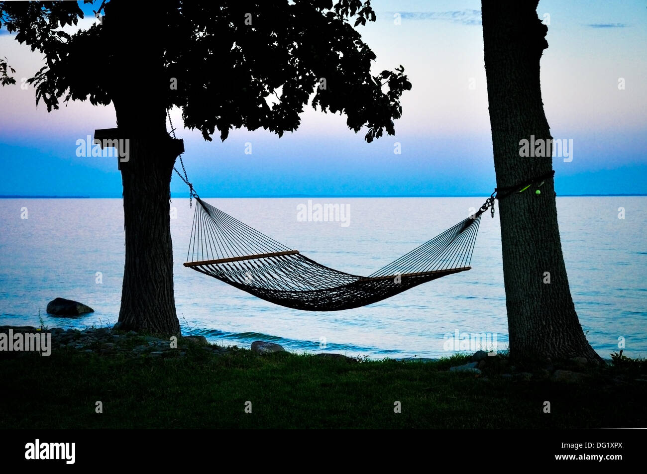 hammock between two trees on shoreline of Lake Ontario New York Stock Photo