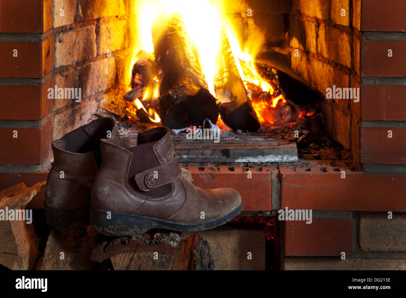 shoes dry near of fire in fireplace in evening time Stock Photo