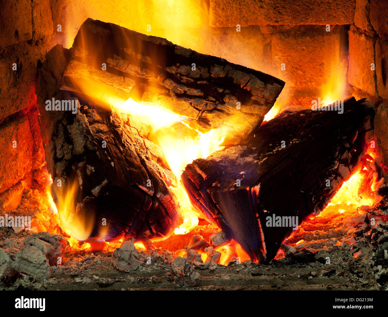 burning fuelwood in fireplace in evening time Stock Photo