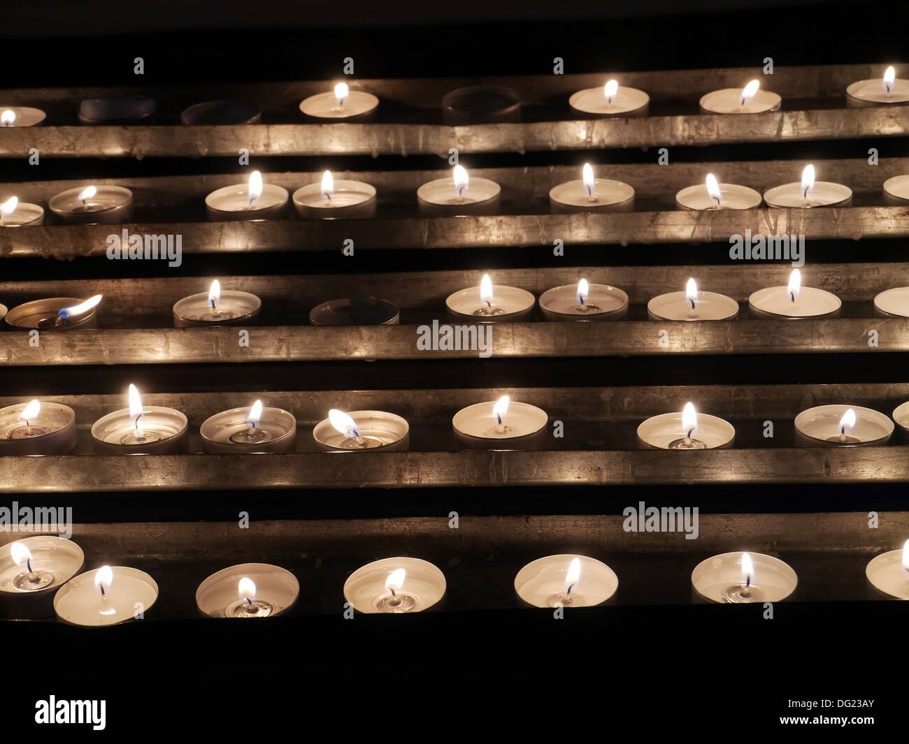 Rows of lit votive candles Stock Photo