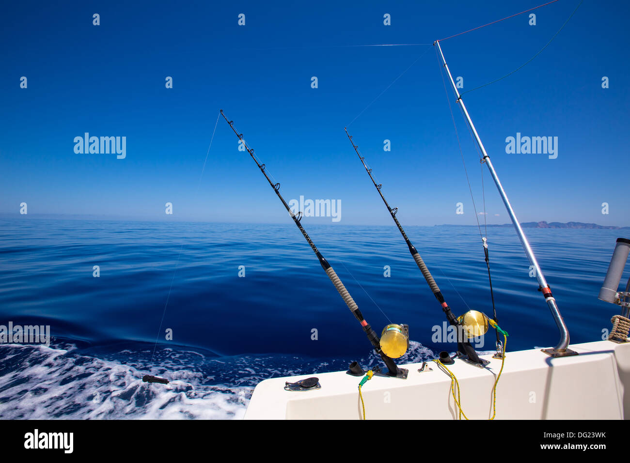 Ibiza fishing boat trolling with rods and reels in blue Mediterranean sea Balearic Stock Photo