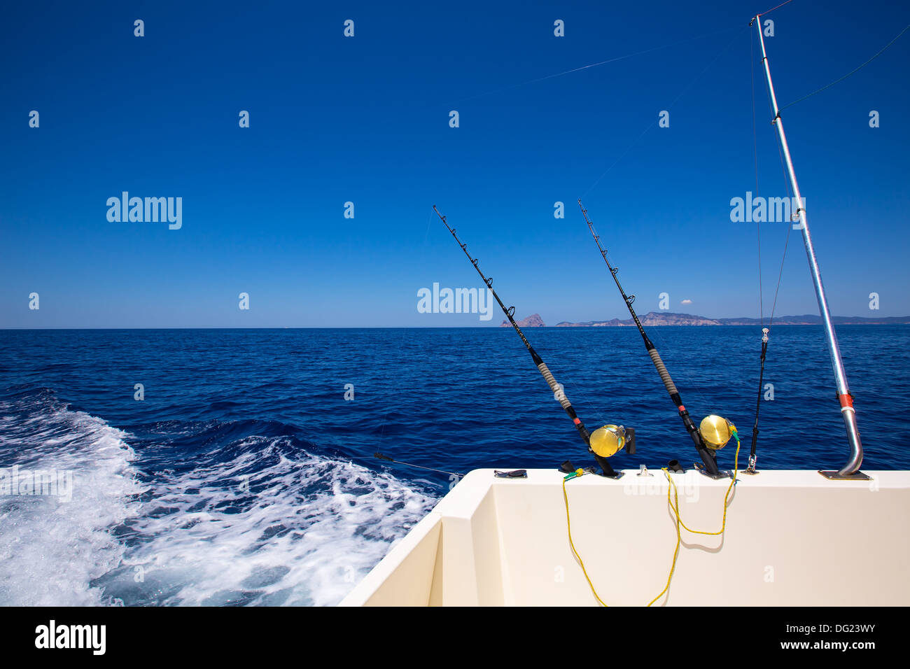 Ibiza fishing boat trolling with rods and reels in blue Mediterranean sea Balearic Stock Photo