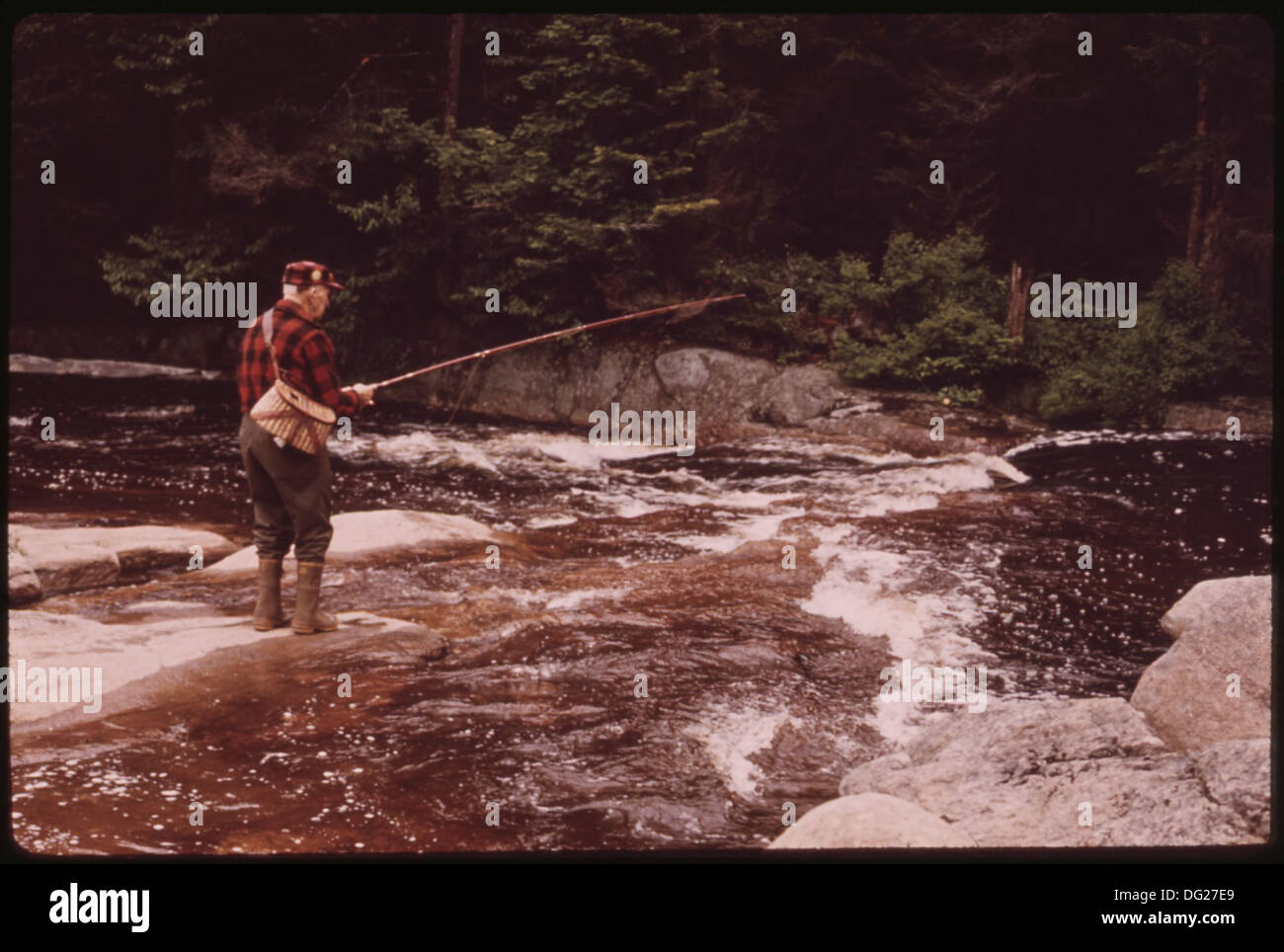 TROUT FISHERMAN FISHING ON TWITCHELL CREEK NEAR BIG MOOSE NEW YORK, IN THE ADIRONDACK FOREST PRESERVE 554520 Landscape Stock Photo