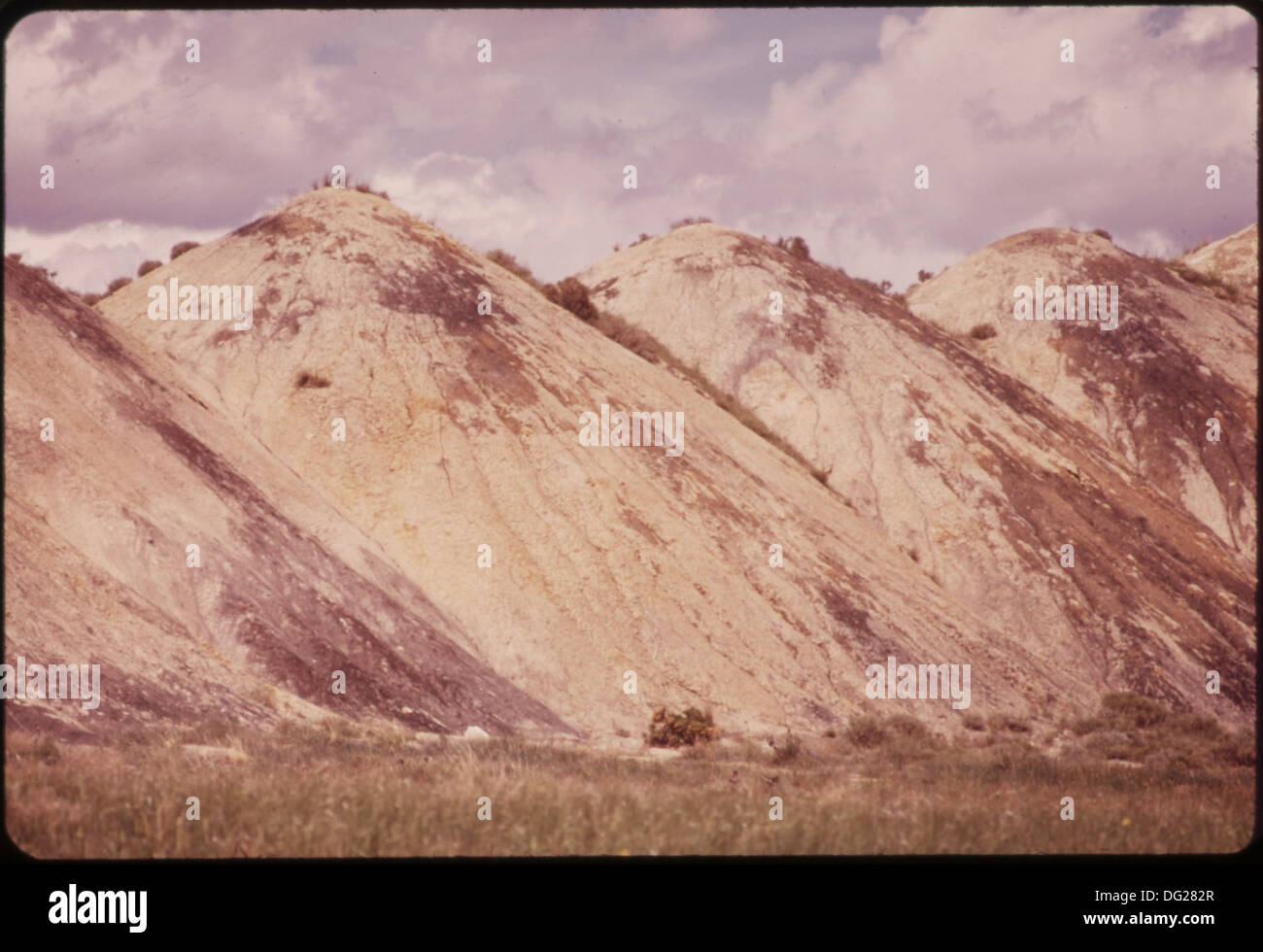 These strip-mining spoil piles, approximately 20 years old, represent the ongoing environmental consequences of strip mining. The piles show minimal vegetation and soil recovery, underscoring the long-term ecological impact of mining activities. Stock Photo