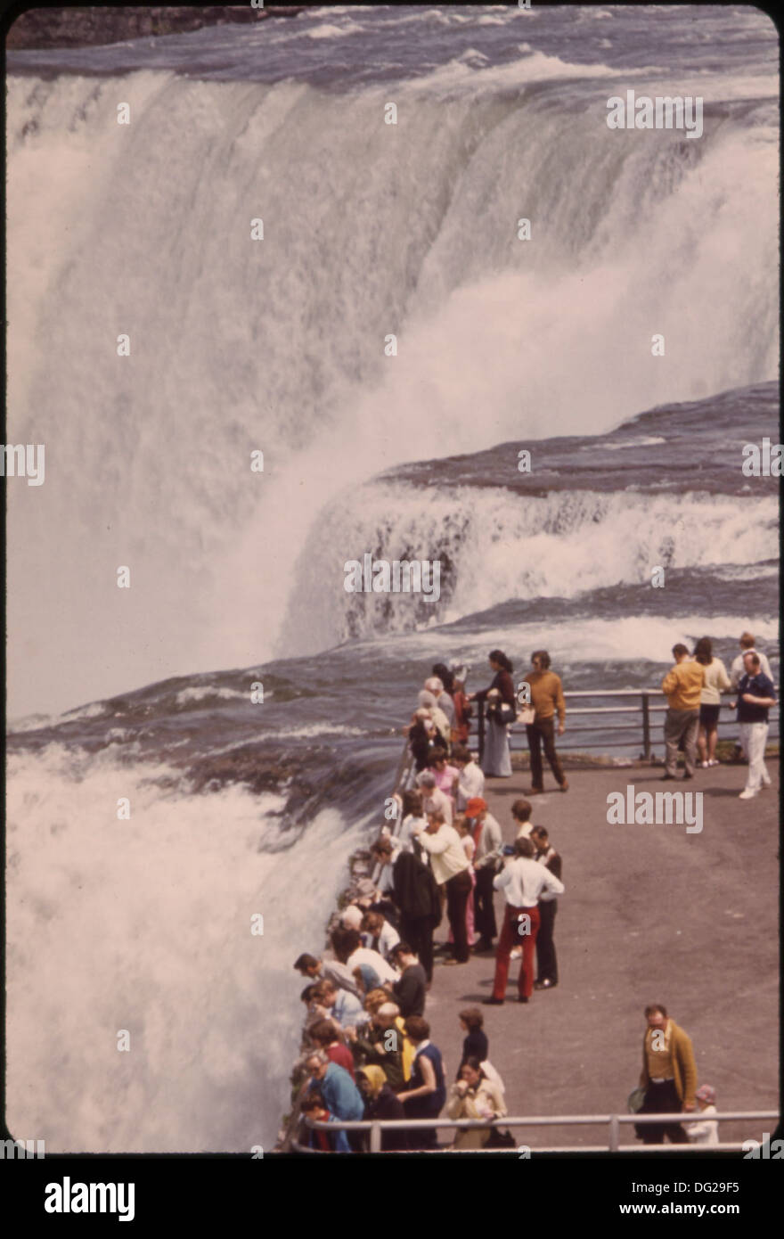 TOURISTS ON GOAT ISLAND AT THE BRINK OF THE CATARACT ENJOY A SPECTACULAR VIEW OF THE AMERICAN FALLS. THE NIAGARA... 549560 Stock Photo