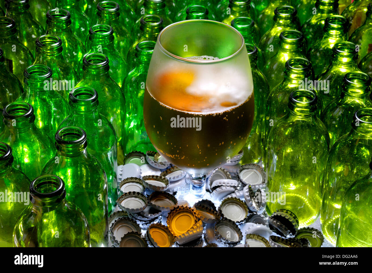 Glass of beer with empty bottles and caps Stock Photo