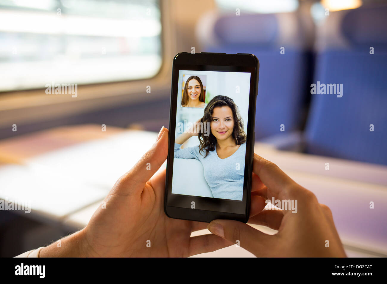 Woman in train chatting on her mobile phone. Video conference Stock Photo