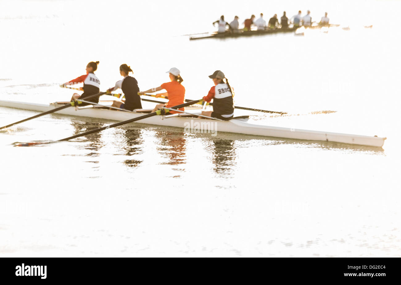 four women rowers practicing on calm  water Stock Photo