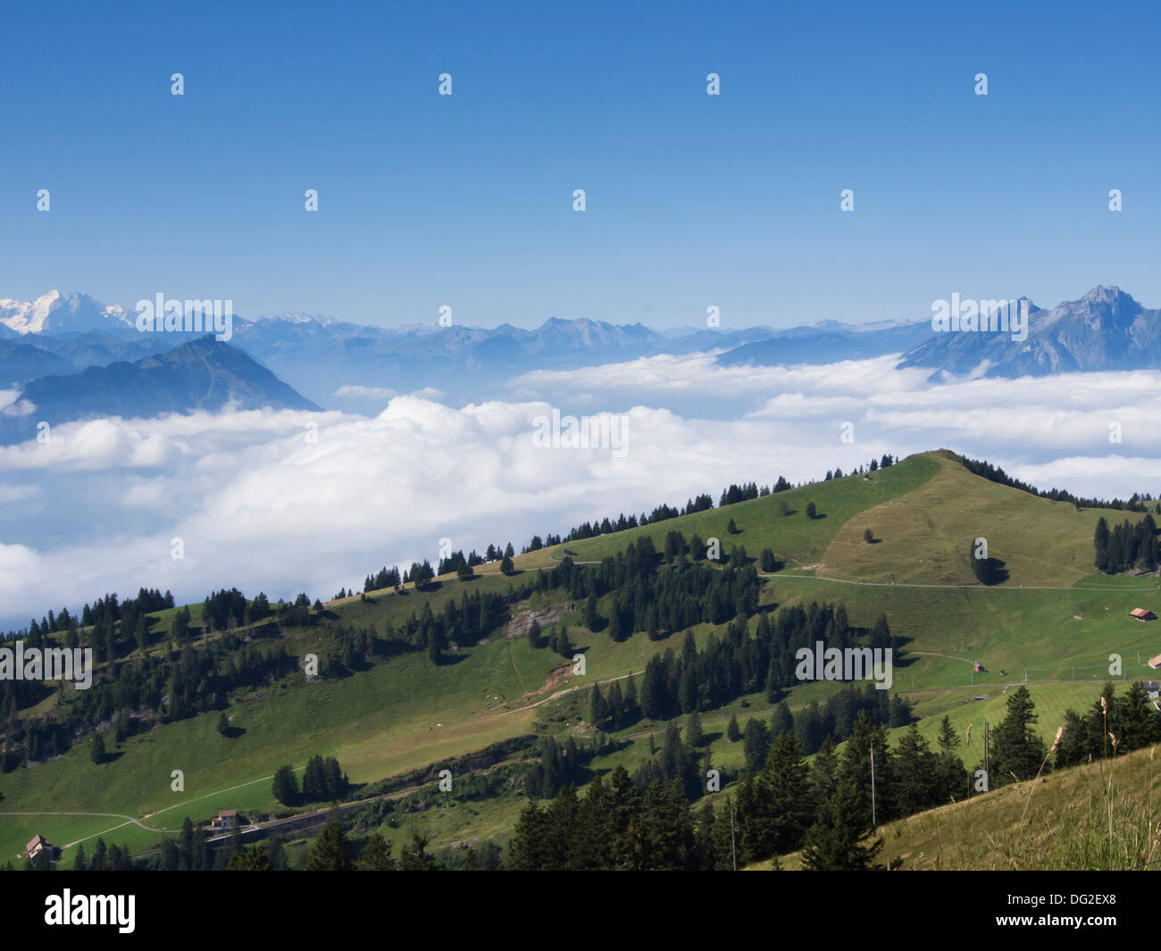 Panorama view from the top of mount Rigi Kulm, Switzerland blue hazy mountains above clouds, pastures green hills trees Stock Photo