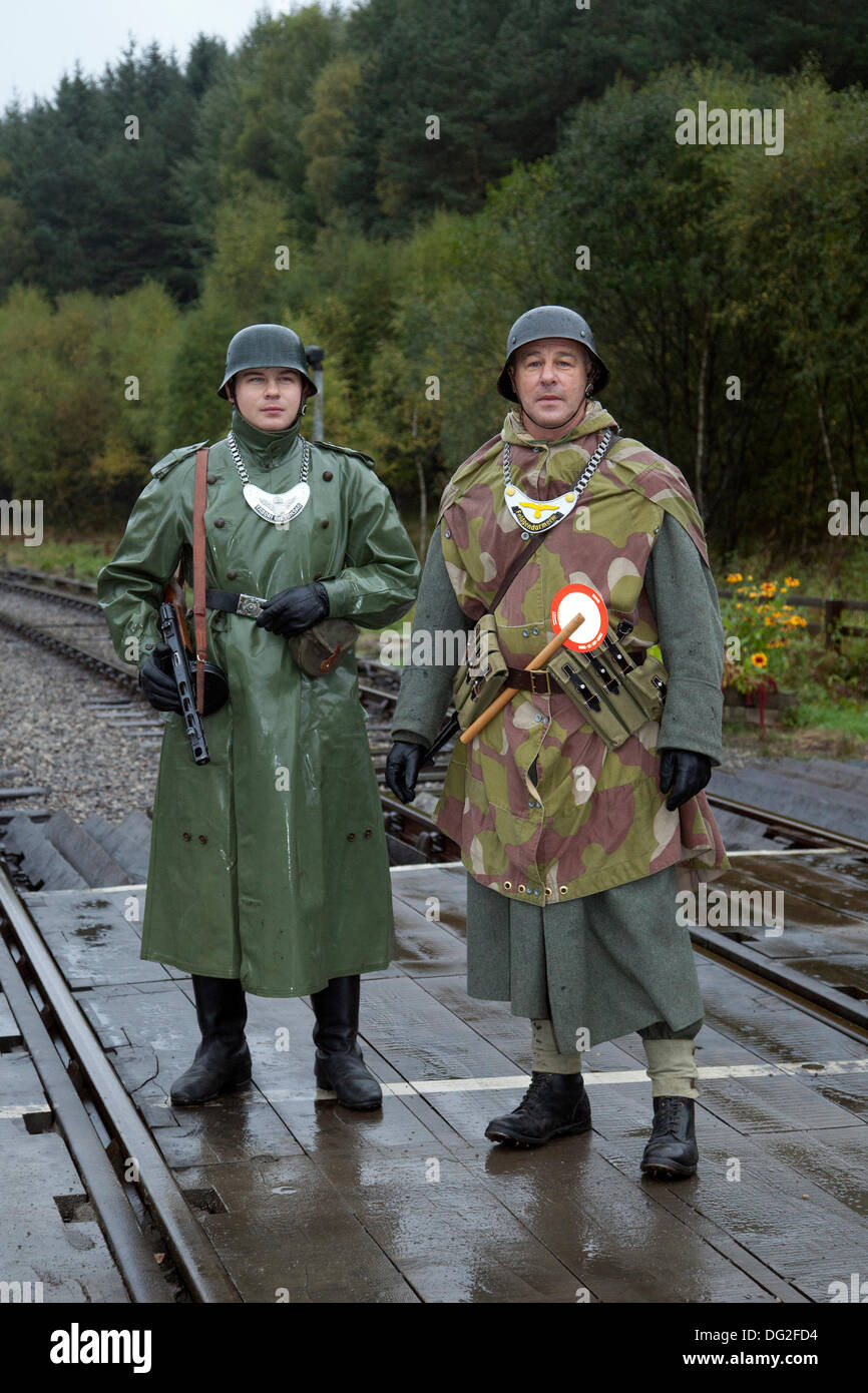 1940 Wartime German army men at Levisham. North Yorkshire, UK.  11th October, 2013. Feld Gendarme at the ‘Railway in Wartime’  North Yorks Moors Railway (NYMR) event at Levisham Railway Station in inclement weather on weekend 12th-13th October 2013.   Levisham Station, was decorated with period posters, and French signs  during the (NYMR) ‘Wartime Weekend’ to become  ‘Le Visham’ in northern France. The gathering, a recreation of a French village occupied by World War Two, World War II, Second World War,  WWII, WW2 German troops. Stock Photo