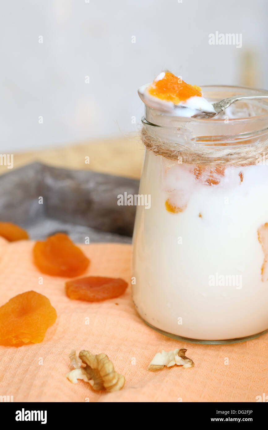 fresh yogurt with pieces of apricot and nuts, food close up Stock Photo