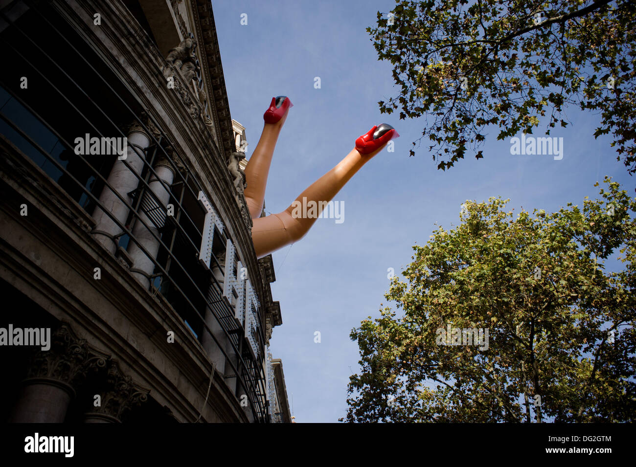 Huge woman inflatable legs at the facade of a theater (Coliseum 'The Hole') in Barcelona, Spain. Stock Photo